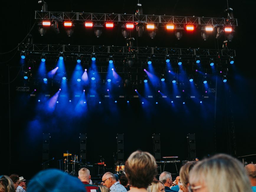 A crowd gathered under stage lights, evoking the energy of a fan convention hall